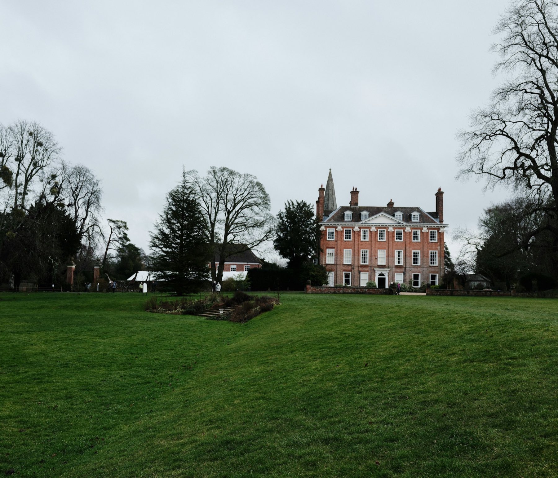 Georgian red-brick manor house surrounded by mature trees